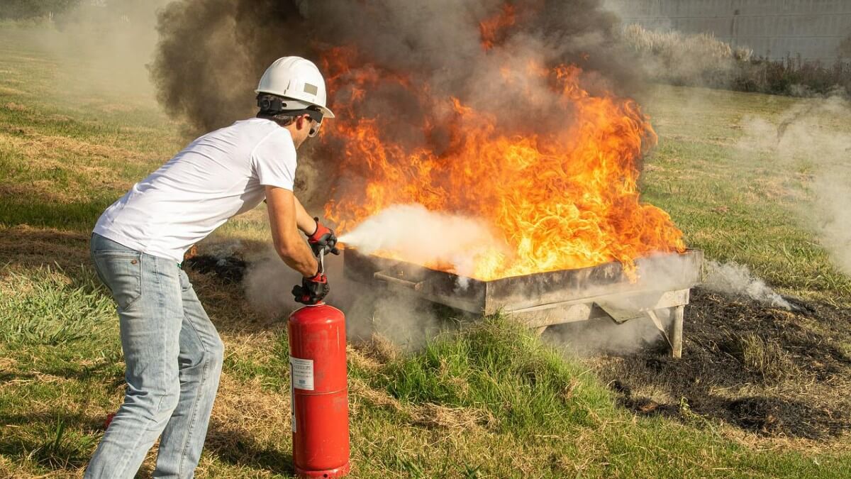 Firefighter putting out fire with fire extinguisher